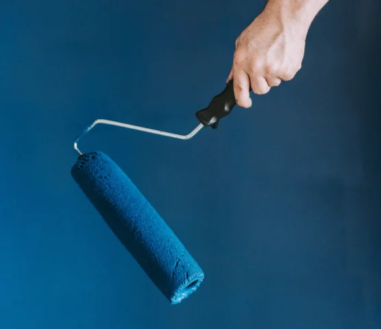 closeup-shot-female-using-paint-rollers-with-color-blue